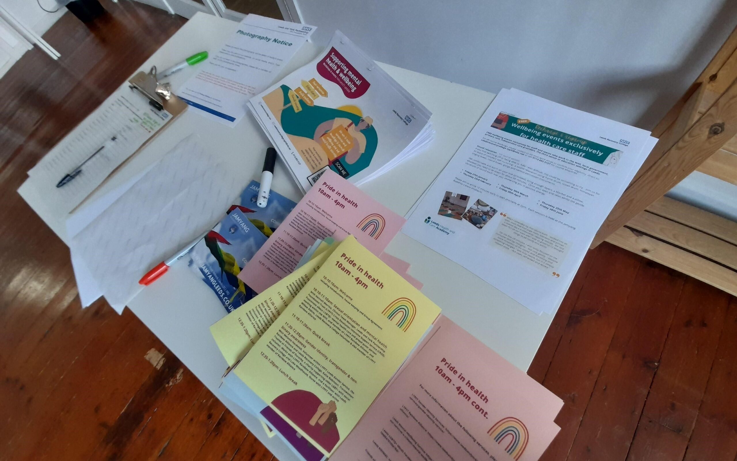 A table with a variety of printed materials laid out for guests attending the Pride in Health event