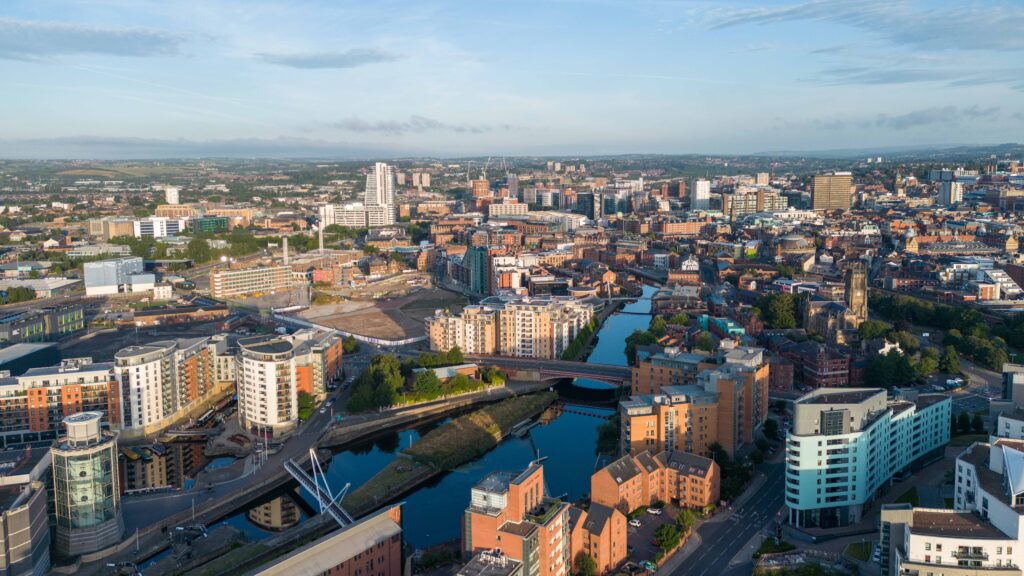 The skyline of Leeds city centre, photographed on a bright day. There are modern blocks of flats and office buildings, the river, tall Bridgewater Place, Kirkate Markets and Leeds Minster, with hills beyond. It looks pretty good in the sunshine!